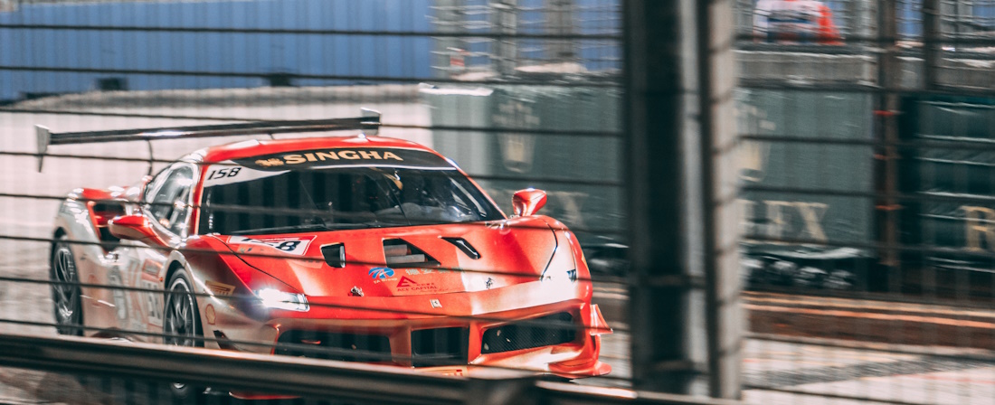 Red Ferrari (#158 Singha) racing in the Singapore circuit