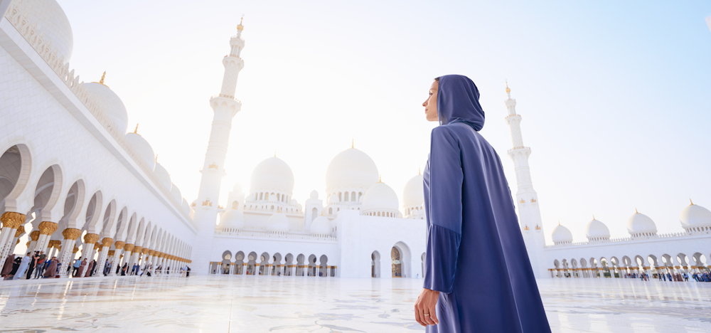 Woman in front of religious buildings in the UAE